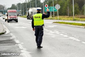 Policjant ruchu drogowego na drodze dający sygnał do zatrzymania