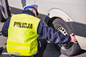 policjant sprawdza ogumienie pojazdu