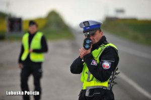 Policjant dokonuje kontroli prędkości pojazdów.