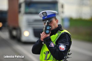 Policjant dokonuje kontroli prędkości pojazdów.