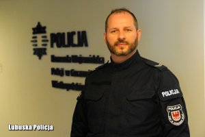 st. sierż. Paweł Olejniczak na tle napisu Komenda Wojewódzka Policji w Gorzowie Wlkp.