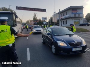 Policjanci przy pojazdach podczas kontroli drogowych.