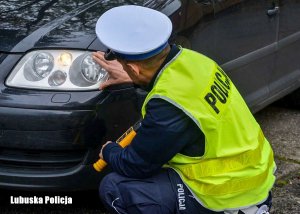 Policjant sprawdza oświetlenie pojazdu.