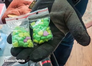 Tabletki w woreczkach na dłoniach policjanta.
