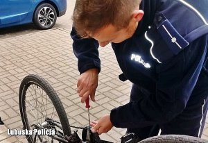 dzielnicowy naprawia rower