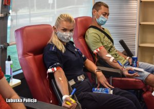Policjantka i mężczyzna podczas oddawania krwi.