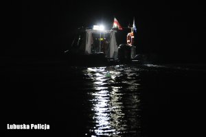 Policyjna motorówka nocną porą nad jeziorem.