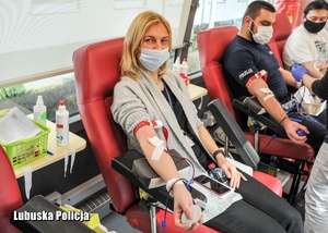 Kobieta i policjant podczas oddawania krwi.