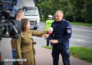 Policjant udzielający wywiadu dziennikarzom.