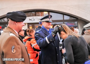 Komendant Wojewódzki Policji podczas wręczenia medali uczestnikom biegu.