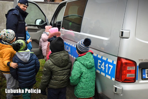Policjantka pokazuje dzieciom policyjny radiowóz
