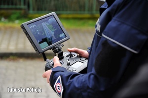 Wyświetlacz kontrolera policyjnego drona w dłoniach policjanta.