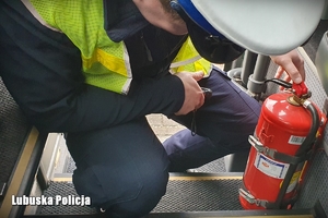 Policjant sprawdza gaśnicę w pojeździe