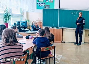 Dzieci z policjantką podczas spotkania profilaktycznego w szkole.