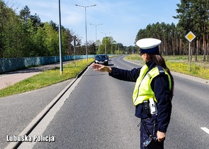 Policjantka drogówki zatrzymuje pojazd do kontroli drogowej.
