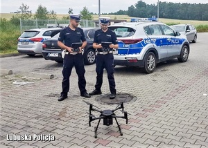 Policjanci podczas sterowania dronem powietrznym.