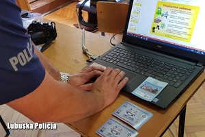 policjant pracuje przy laptopie