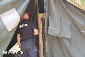 policjant sprawdza namiot w obozie