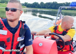Policjant i ratownik wodny patrolują jezioro.
