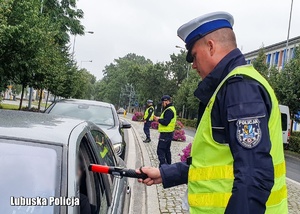 Policjanci drogówki sprawdzają trzeźwość kierowców pojazdami.