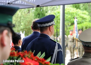 Komendant Wojewódzki Policji stojący z innymi funkcjonariuszami podczas uroczystości rocznicowych.