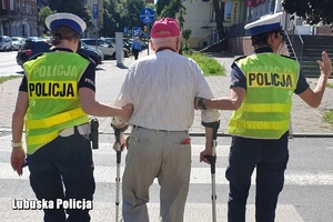 policjantki pomagają seniorowi przejść przez drogę