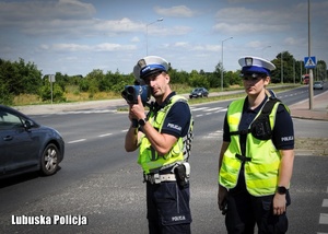 Policjanci podczas kontrolowania prędkości jadących pojazdów.