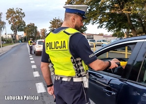 Policjanci ruchu drogowego kontrolują stan trzeźwości kierowców na drodze.