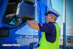 Policjant drogówki podczas kontroli drogowej ciężarówki.