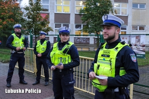 Policjanci w kamizelkach odblaskowych stojący na chodniku