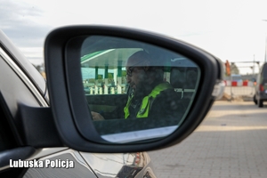 Policjant widoczny w lusterku bocznym pojazdu