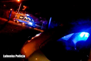 radiowóz i karetka stoją na drodze nocą