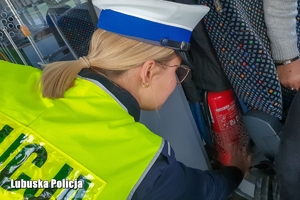 Policjantka sprawdza obowiązkowe wyposażenie pojazdu