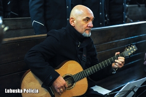 Mężczyzna gra na gitarze podczas nabożeństwa.