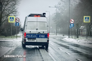 radiowóz Policji jedzie po drodze
