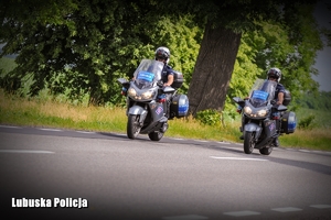 Policjanci jadący na motocyklach służbowych