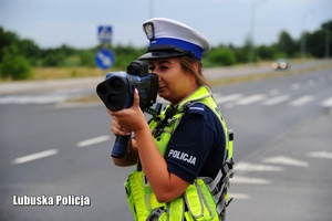Policjantka sprawdza prędkość poruszających się pojazdów