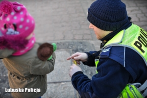 Policjant wręcza odblask dziecku