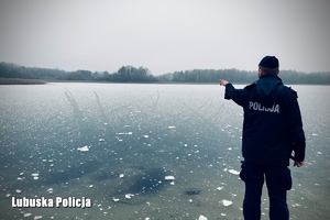 Policjant stojący przed zamarzniętym jeziorem