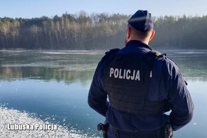 Policjant kontroluję jezioro w trakcie zimy