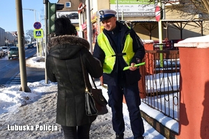 Policjant przekazuje odblask dla kobiety