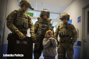 Policyjni kontrterroryści robią zdjęcie z dzieckiem