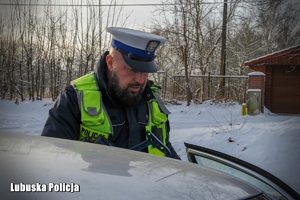 Policjant rozmawia z kierowcą pojazdu podczas kontroli drogowej.