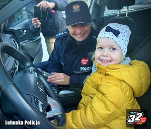 uśmiechnięta policjantka w radiowozie z dzieckiem