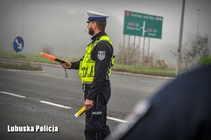 Policjant ruchu drogowego daje znak do zatrzymania