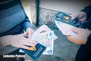 Policjant wraz z kobietą trzymają broszury informacyjne